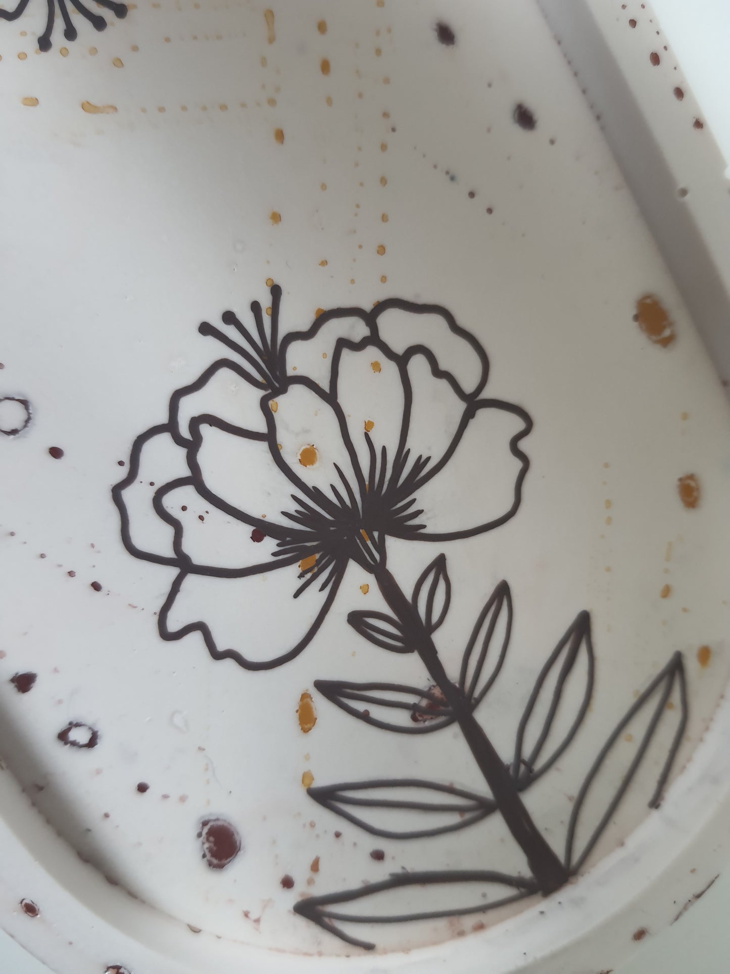 Close up view of hand painted flower on cream trinket dish